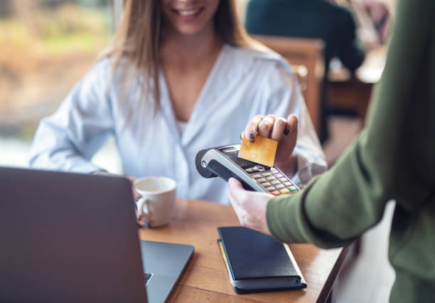 istock Woman In Cafeteria Paying With Credit Card 1354910039