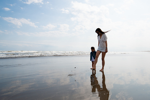 Mother and child walking on the beach