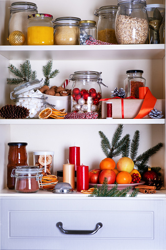 Christmas concept. Preparation for holiday. Contents of kitchen cabinet with cristmas supplies and decor. Selective focus.