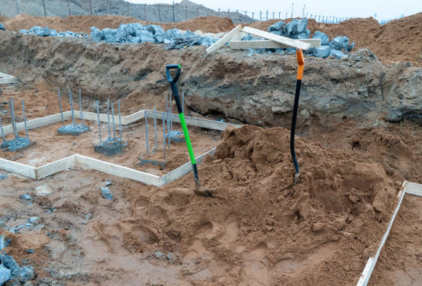 foto di barre metalliche da costruzione in pilastri e pale di cemento per scavare il terreno sullo sfondo di un cantiere e attrezzature sulla strada - basement concrete construction form foto e immagini stock