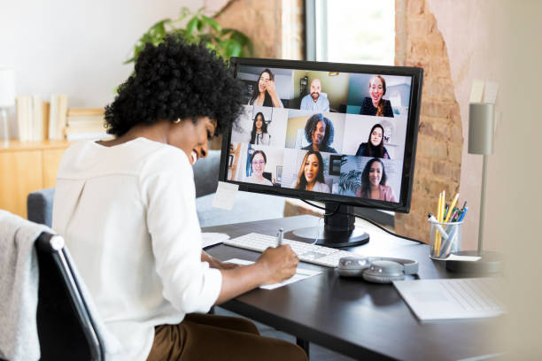 istock Mid adult businesswoman meets virtually with co-workers 1354923988