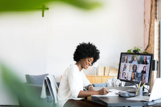 istock Sitting in office, businesswoman smiles while taking notes during meeting 1354923995
