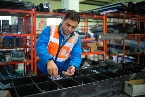 Warehouse male worker examining goods in factory