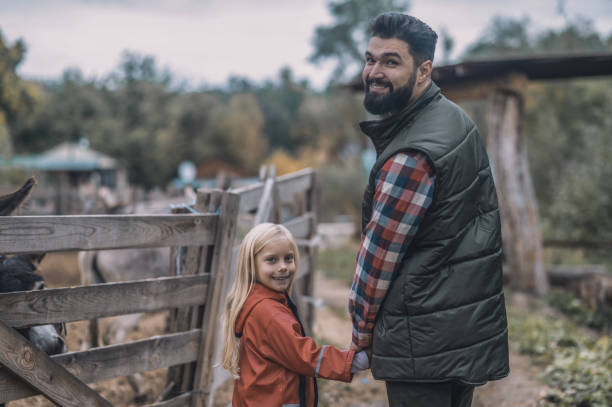 istock Farmer and his daughetr walking together hand in hand 1354924725