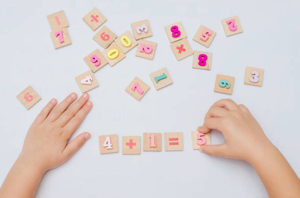 istock Five year old child learn learns arithmetic using a set of wooden numbers 1354926312