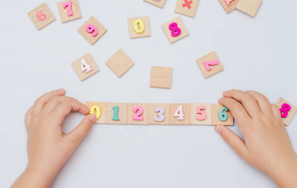 istock Five year old child learn learns arithmetic using a set of wooden numbers 1354926315