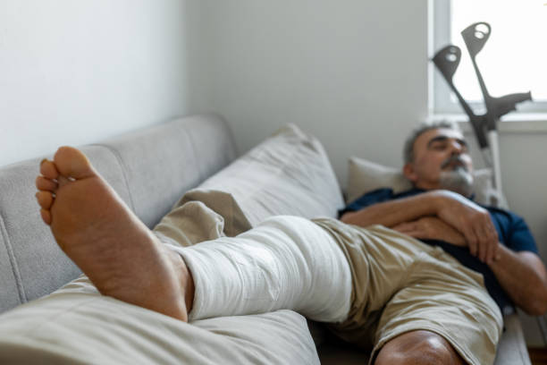 istock Man's leg uses crutches to walk after surgery 1354926384