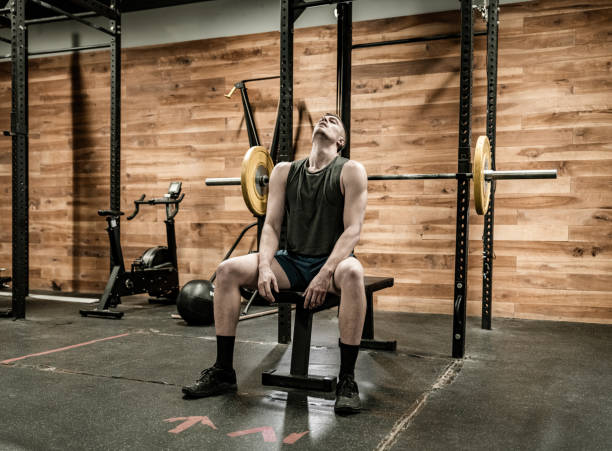 istock Young Man lifting weights in the Gym 1354926580