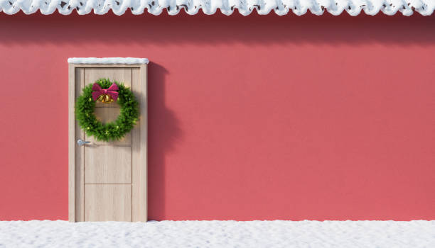 istock Facade with snow and a door decorated for Christmas. 1354926590