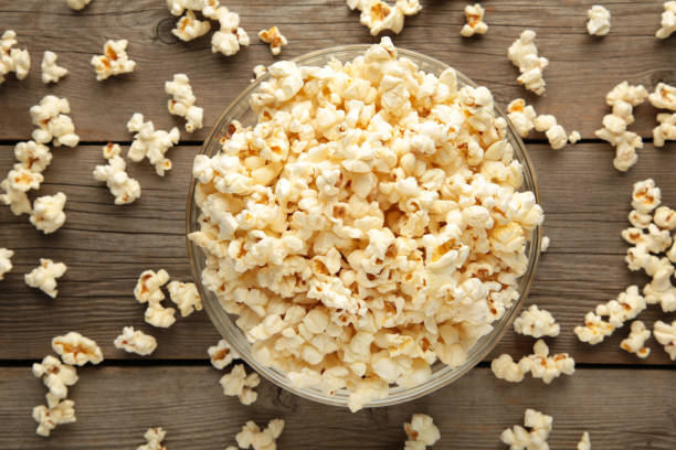 istock Popcorn in glass bowl on grey wooden background. 1354926724