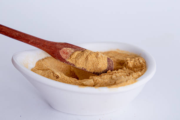 istock Peruvian maca powder with rustic wooden spoon on a white background. selective focus 1354930393
