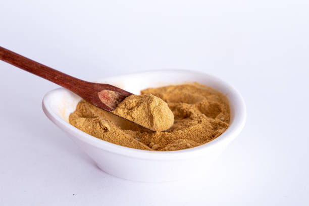 istock Peruvian maca powder with rustic wooden spoon on a white background. selective focus 1354930461