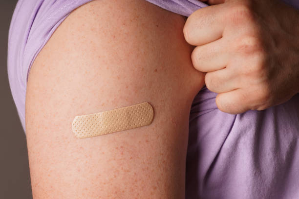 istock Medical patch, bandage or plaster on a man's shoulder after vaccination 1354931254
