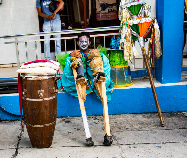 Conga drum player and stilt walker takes a break from a gig in Pinar de Rio, Cuba. stock photo