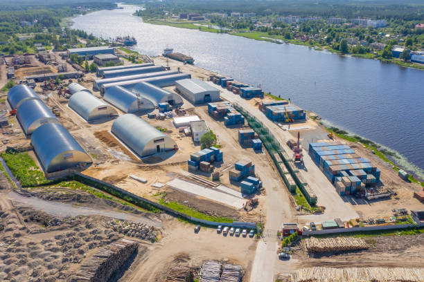 istock Small industrial port for timber logs and containers, loading and unloading on sea and rail transport. Aerial view. 1354935311