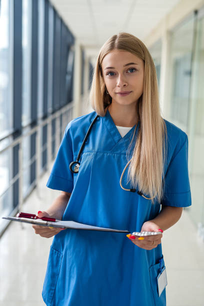istock beautiful young nurse standing in  hallway with a tablet 1354936453