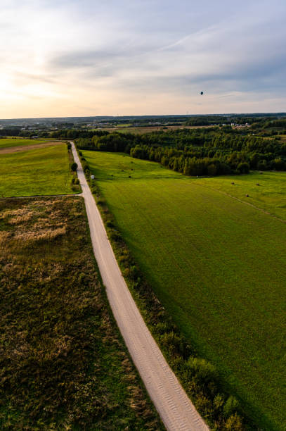 Hot air balloons flying above country roads fields and forests in Lithuania Vilnius, Lithuania - September 14, 2021: Hot air balloons flying above country roads fields and forests in Lithuania low viewing point stock pictures, royalty-free photos & images