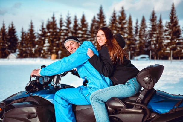 istock Smiling Couple Having Fun With Snowmobile In Mountain Snow 1354937289