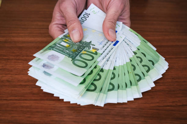 istock Handing over money. Euro bills. 1354937993