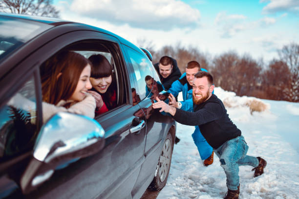 Males Trying To Get Car Out Of Mountain Snow By Pushing While Females Drive It Males Trying To Get Car Out Of Mountain Snow By Pushing While Females Drive It doing a favor stock pictures, royalty-free photos & images