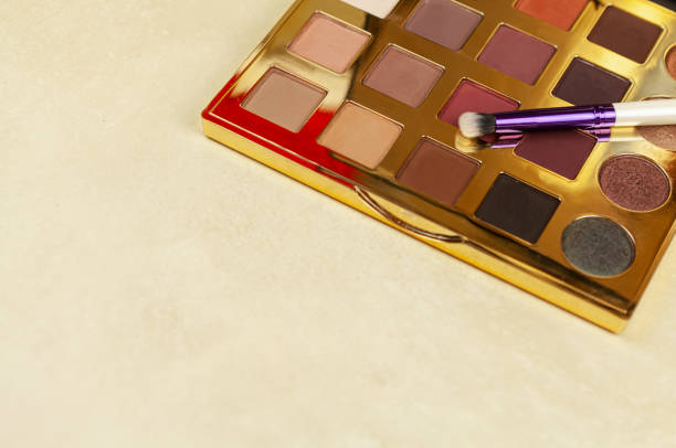 istock Neutral eyeshadow palette with tassels on beige background 1354938702