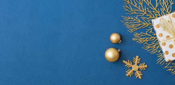 Christmas holiday banner background with copyspace. Flat lay frame with christmas balls and gift box on a blue background