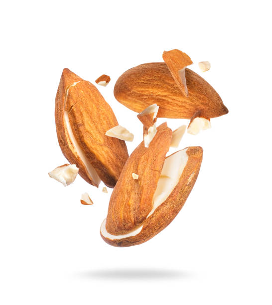 istock Dried almonds crushed in the air into pieces isolated on white background 1354940164