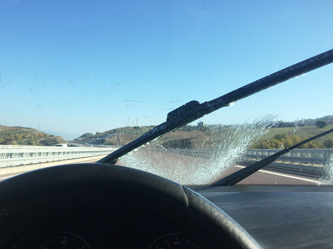 Washing the car windscreen with windshield wiper on the road