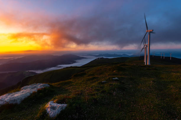 wind turbines farm at sunrise, oiz mountain, basque country, spain - green business imagens e fotografias de stock