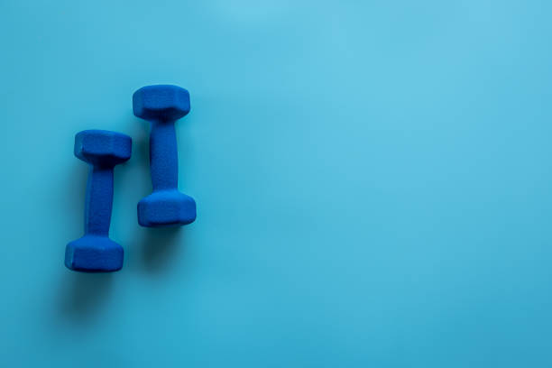istock Sports dumbbells flat lay isolated on blue. 1354944668
