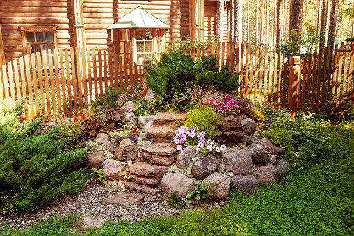 Rock garden made of large stones of different types of flowers