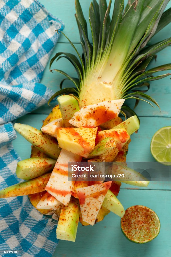 Pepino, jícama y piña con chile en polvo y salsa chamoy sobre fondo turquesa. Merienda mexicana - Foto de stock de Alimento libre de derechos