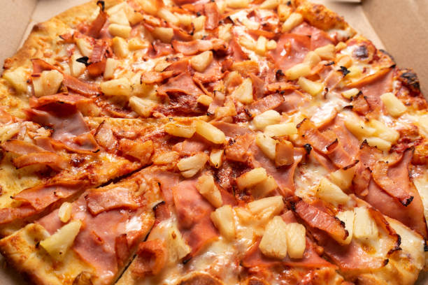 istock Ham and pineapple pizza called hawaiian on a wooden background 1354952626