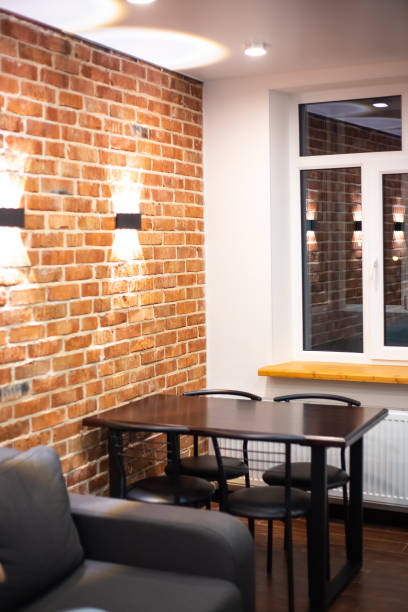 istock Living room interior in loft style. Sofa and dining table on a brick wall background with lamps 1354953871