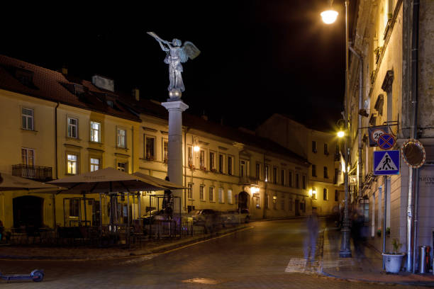 Vilnius, Lithuania - November 1, 2021: Night view of Uzupis Angel sculpture (sculptor Romas Vilciauskas, 2002) in the central square of Uzupis district.
