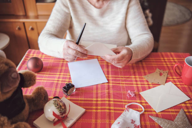 istock Senior woman closing an envelope on Christmas 1354955215