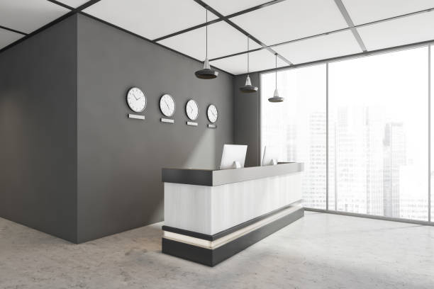 istock Grey and white office lobby with double seater front desk. Corner view. 1354955819