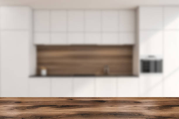 istock Wooden table with modern minimalist white kitchen cabinet on the background 1354956154