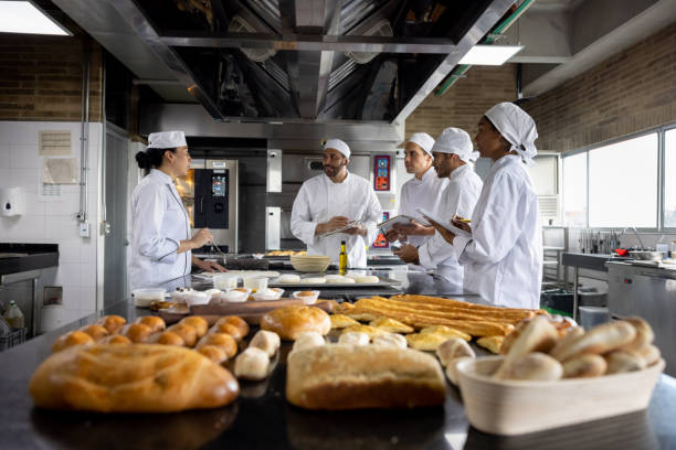 insegnante in una classe di cottura che spiega ai suoi studenti come fare il pane - baking baker bakery bread foto e immagini stock