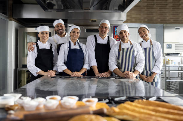 istock Happy group of bakers baking bread at the bakery 1354962826