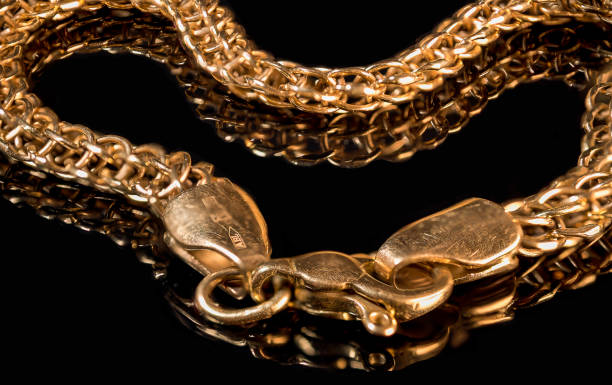 istock Gold handmade bracelet on black background 1354966908