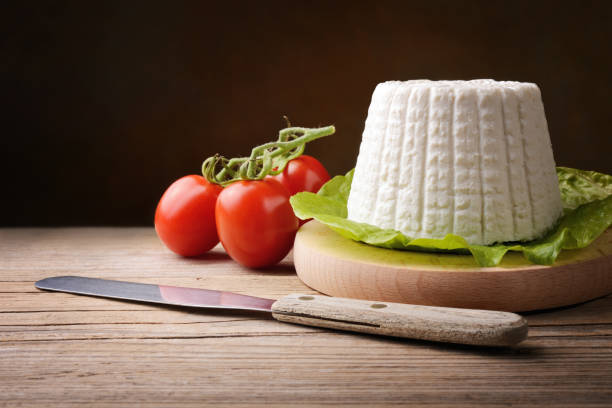 Ricotta cheese and tomatoes on old wooden table, space for text. Fresh cottage cheese on cutting board, copy space, close-up. ricotta stock pictures, royalty-free photos & images