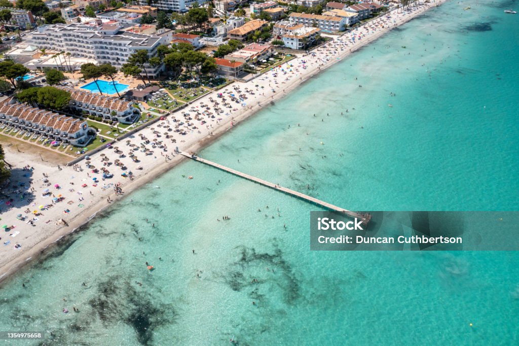 Aerial drone photo of the beach front on the Spanish island Majorca Mallorca, Spain showing the beach known as Platja de Muro in the village of Alcúdia on a sunny summers days Beach Stock Photo