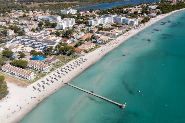 Aerial drone photo of the beach front on the Spanish island Majorca Mallorca, Spain showing the beach known as Platja de Muro in the village of Alcúdia on a sunny summers days stock photo