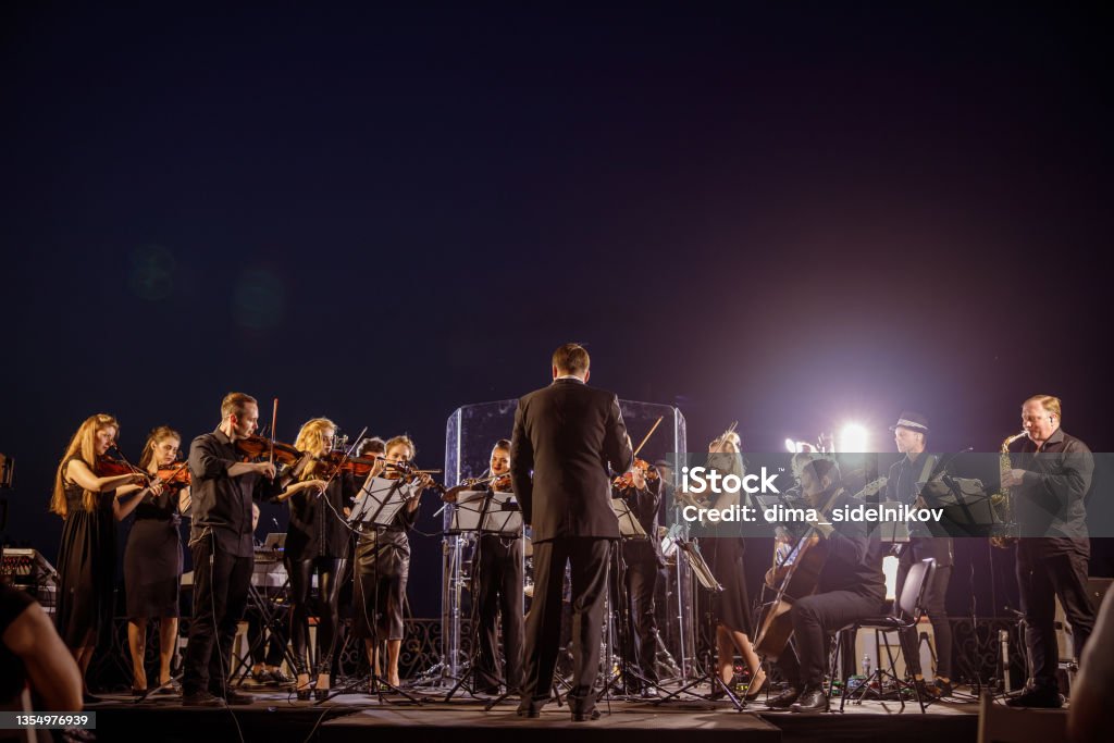 Orchestra performing live concert under blue night sky - Royalty-free Orquestra Foto de stock