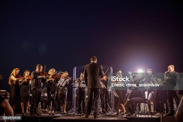 Orchestra Performing Live Concert Under Blue Night Sky - Fotografias de stock e mais imagens de Orquestra