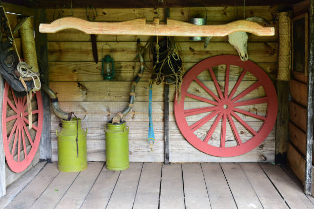 istock rustic farm setting with wooden wheels, tools roosters, for texture background use. 1354977177
