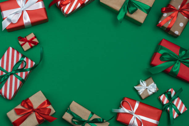 istock Christmas composition with a copy space. Above view layout of wrapped present boxes on emerald green paper background 1354981811