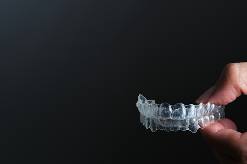 retenedores dentales transparentes de mano sobre fondo negro photo