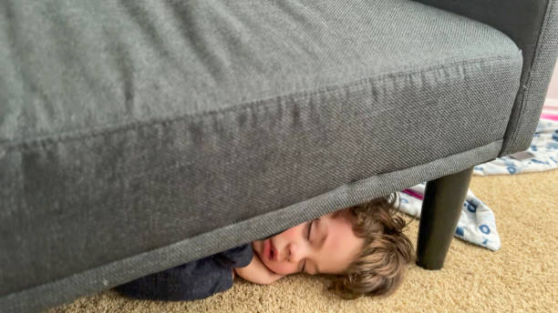 istock Sleepy Boy Fell Asleep Under the Couch 1354984017